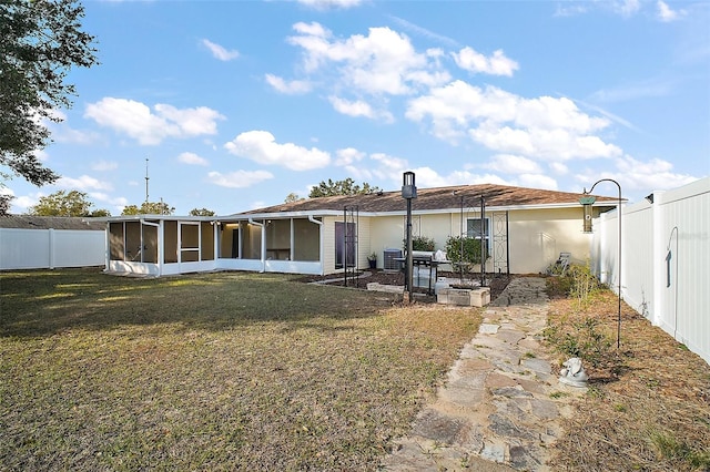 rear view of property with a sunroom and a yard