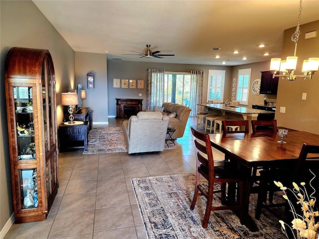 tiled dining area featuring ceiling fan with notable chandelier