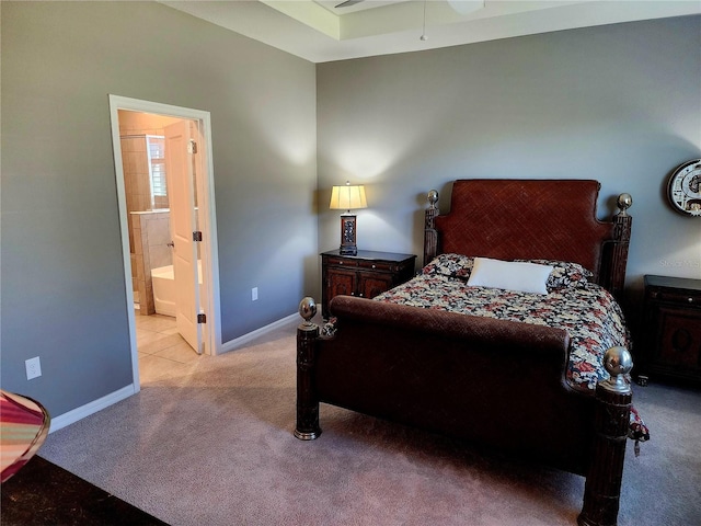 bedroom with connected bathroom, light colored carpet, and ceiling fan