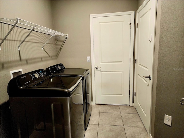 laundry room featuring light tile patterned floors and washing machine and clothes dryer