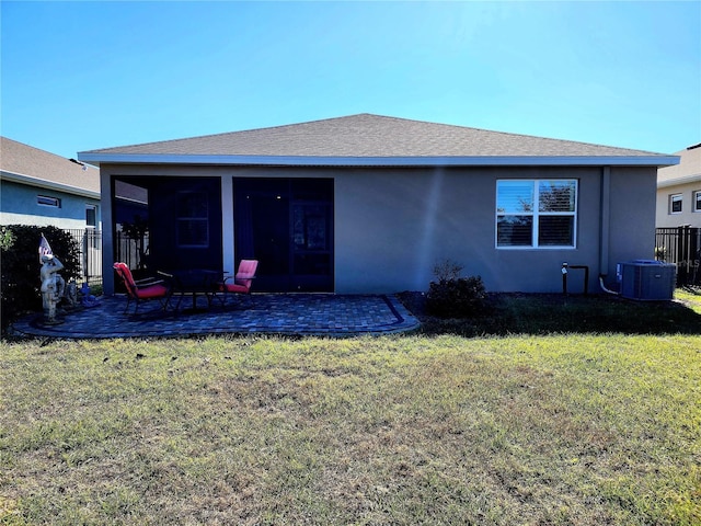 back of house with a lawn, a sunroom, central air condition unit, and a patio