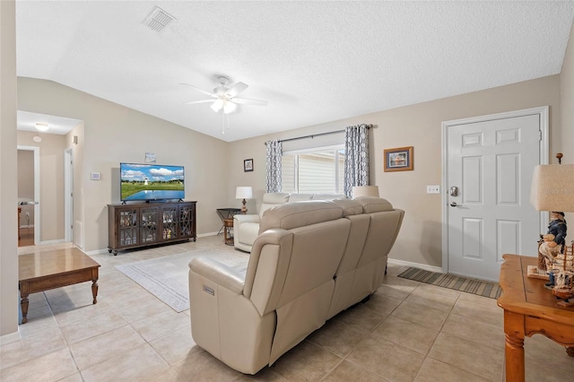 tiled living room with ceiling fan, a textured ceiling, and vaulted ceiling