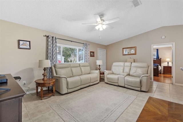 tiled living room with a textured ceiling, ceiling fan, and vaulted ceiling