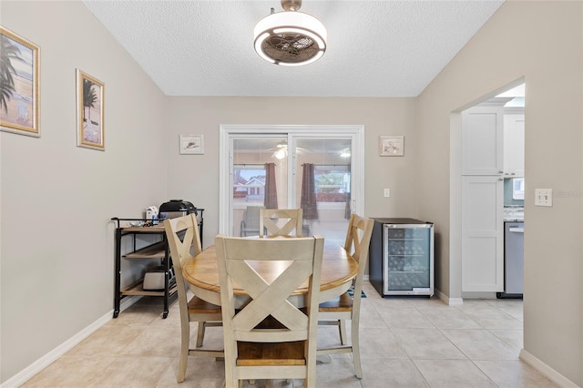 tiled dining area with a textured ceiling and wine cooler