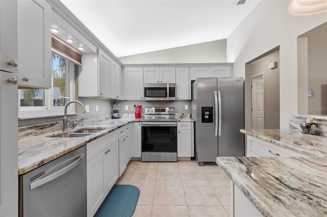 kitchen featuring white cabinetry, sink, lofted ceiling, and stainless steel appliances