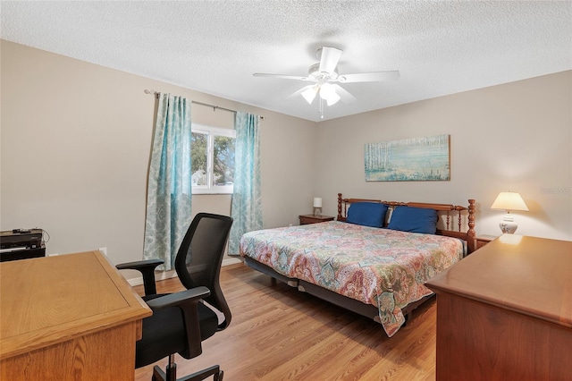 bedroom featuring ceiling fan, light hardwood / wood-style floors, and a textured ceiling