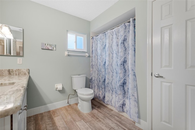 bathroom featuring a shower with curtain, vanity, a textured ceiling, and toilet