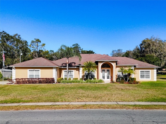 ranch-style house with french doors and a front lawn