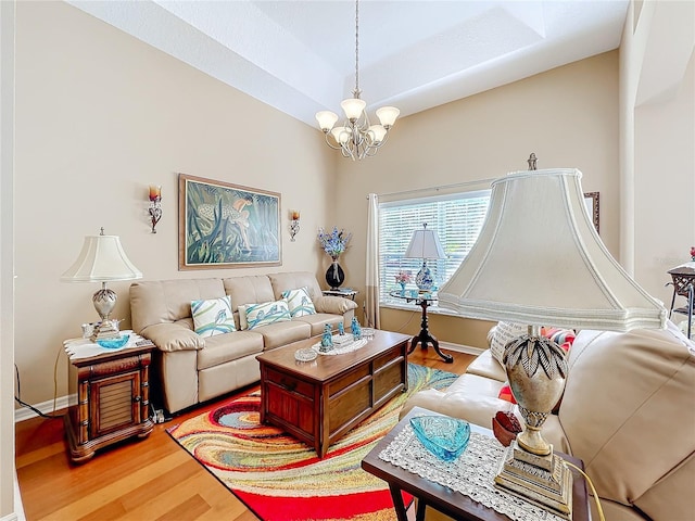 living room with hardwood / wood-style floors, a chandelier, and vaulted ceiling