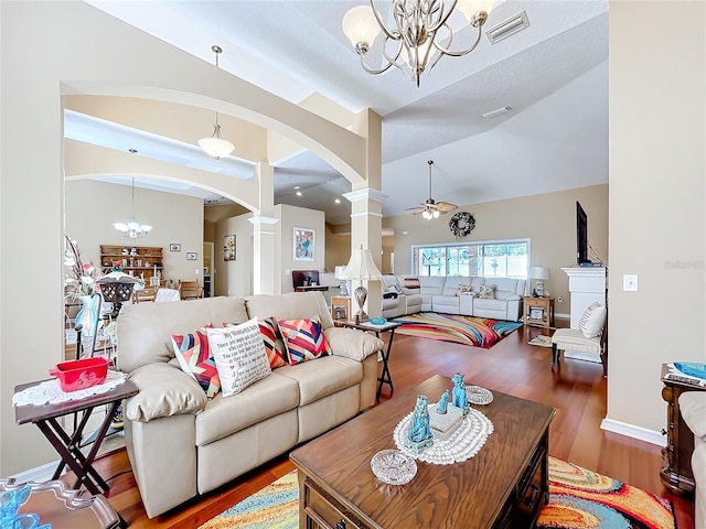 living room featuring ornate columns, a textured ceiling, ceiling fan with notable chandelier, vaulted ceiling, and hardwood / wood-style flooring