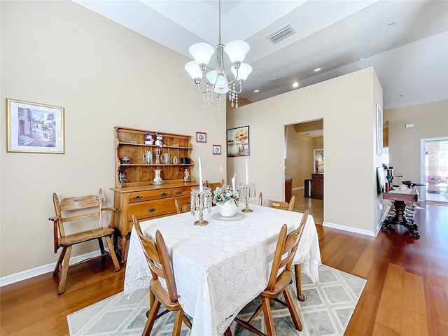 dining area featuring hardwood / wood-style floors and a chandelier