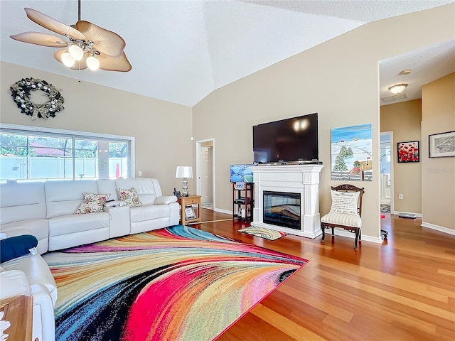 living room featuring wood-type flooring, ceiling fan, and lofted ceiling