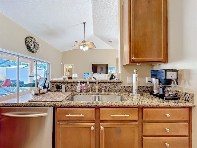 kitchen with stainless steel dishwasher, a textured ceiling, vaulted ceiling, ceiling fan, and sink