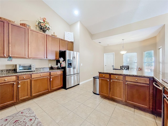 kitchen featuring light stone counters, decorative light fixtures, stainless steel fridge with ice dispenser, lofted ceiling, and light tile patterned flooring