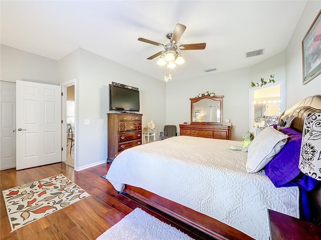 bedroom with dark hardwood / wood-style flooring and ceiling fan