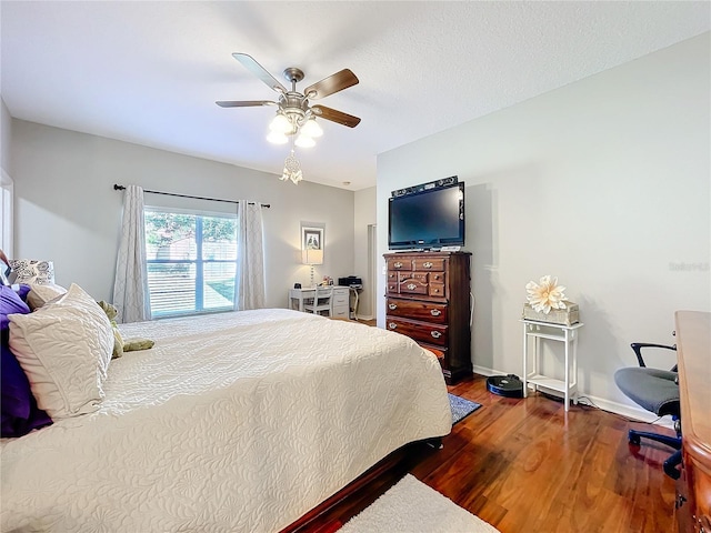 bedroom with a textured ceiling, ceiling fan, and dark hardwood / wood-style floors