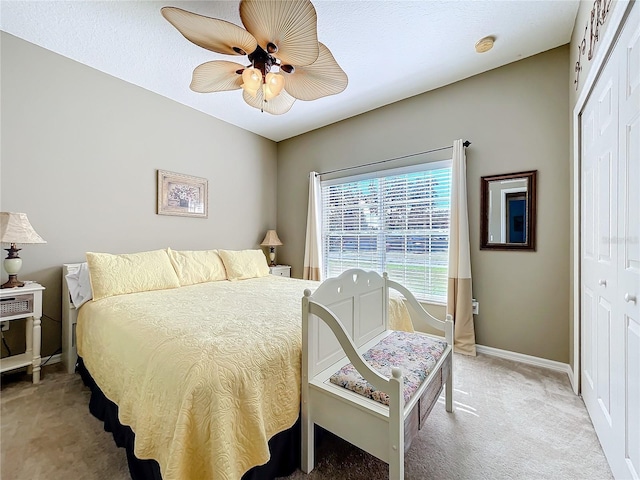 carpeted bedroom with ceiling fan and a closet