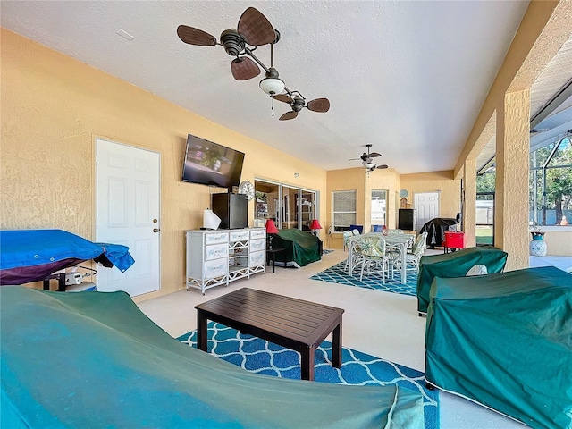 carpeted living room with a textured ceiling and ceiling fan