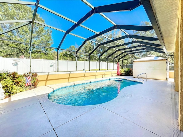 view of pool featuring glass enclosure and a patio