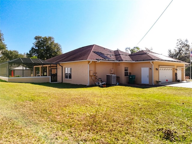 view of property exterior with a lanai, central AC, a yard, and a garage