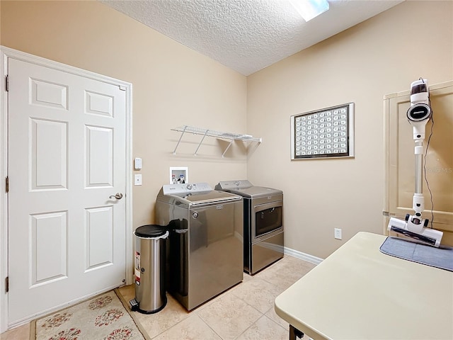 laundry room with independent washer and dryer, a textured ceiling, and light tile patterned floors