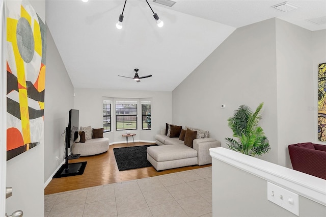 tiled living room featuring ceiling fan and vaulted ceiling