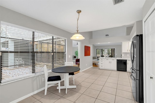 kitchen featuring dishwasher, white cabinets, stainless steel fridge, light tile patterned floors, and decorative light fixtures