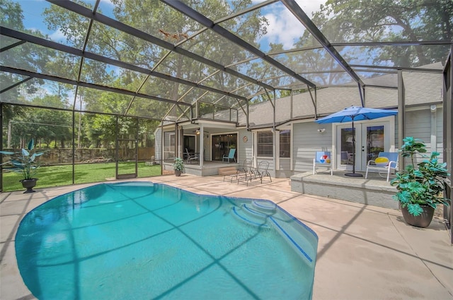 view of swimming pool featuring a lanai, a patio area, and french doors