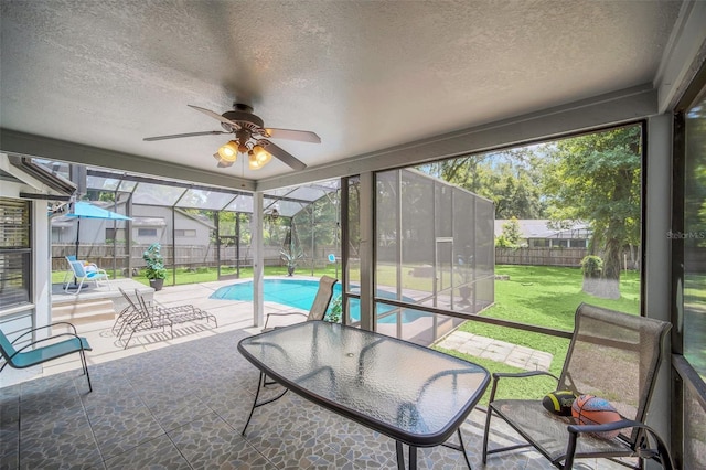 sunroom featuring ceiling fan and plenty of natural light