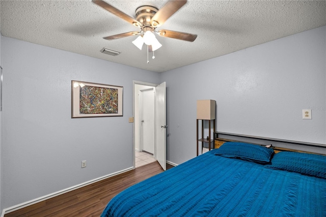 bedroom featuring a textured ceiling, light hardwood / wood-style floors, and ceiling fan