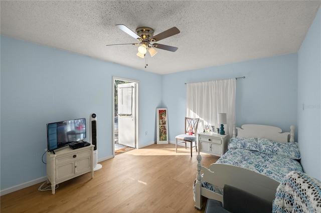 bedroom featuring ceiling fan, a textured ceiling, and light hardwood / wood-style flooring