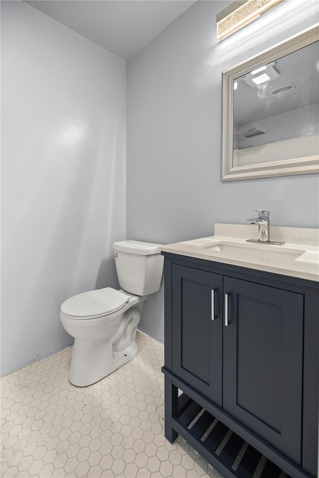 bathroom with tile patterned flooring, vanity, and toilet