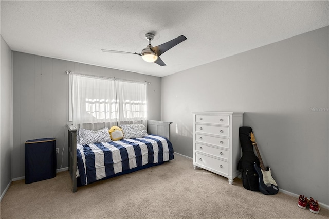 bedroom with a textured ceiling, light colored carpet, and ceiling fan