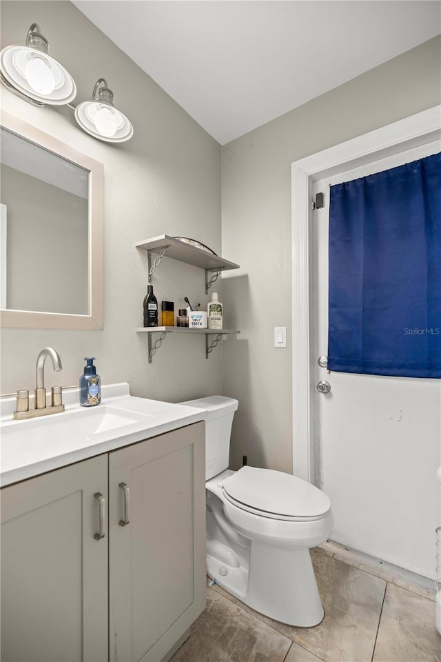 bathroom with tile patterned flooring, vanity, and toilet