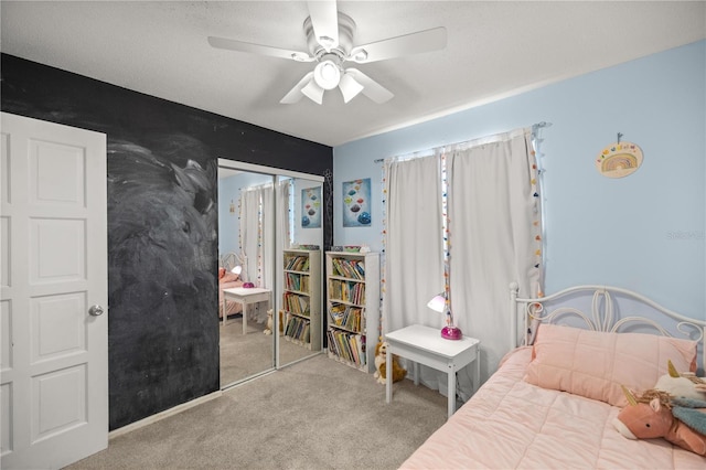 bedroom with ceiling fan, a closet, light colored carpet, and a textured ceiling