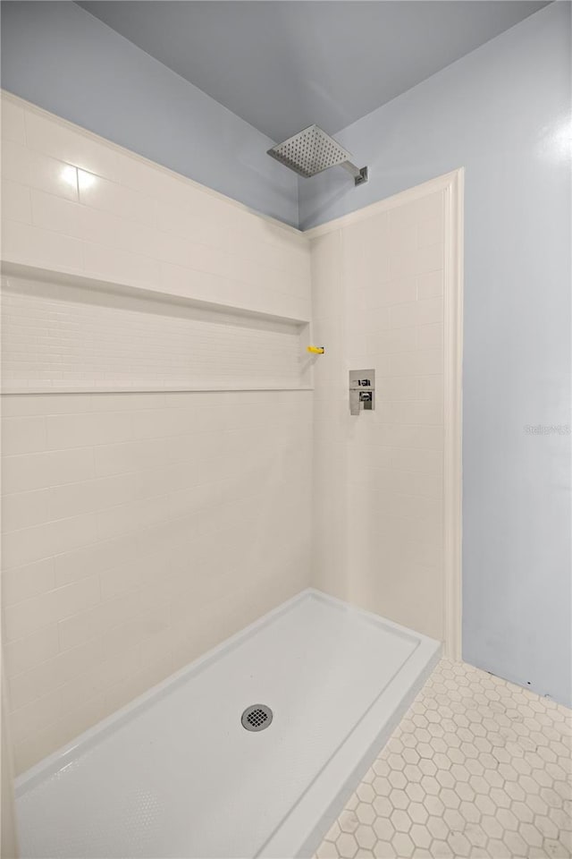 full bathroom with tile patterned flooring and tiled shower