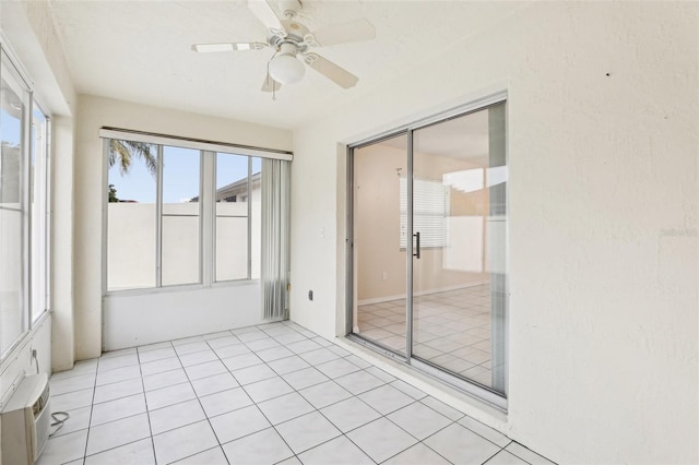 unfurnished sunroom with ceiling fan