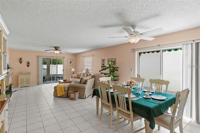 tiled dining room with a textured ceiling and ceiling fan