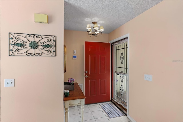 entrance foyer featuring a textured ceiling, a notable chandelier, and light tile patterned flooring