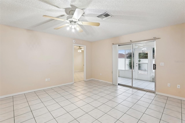 tiled empty room with ceiling fan and a textured ceiling