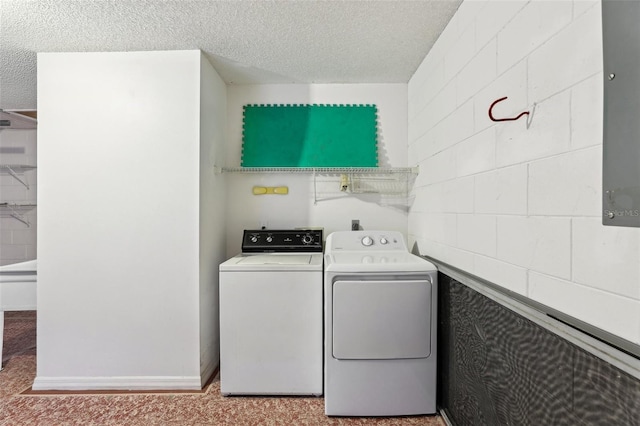 laundry room featuring washer and clothes dryer and a textured ceiling