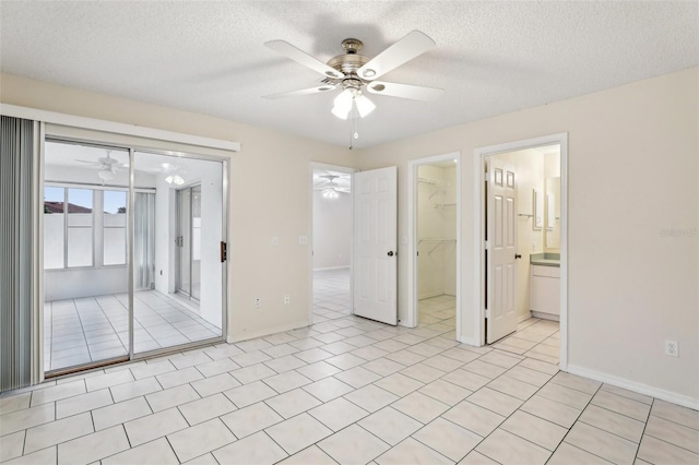 tiled empty room with a textured ceiling and ceiling fan