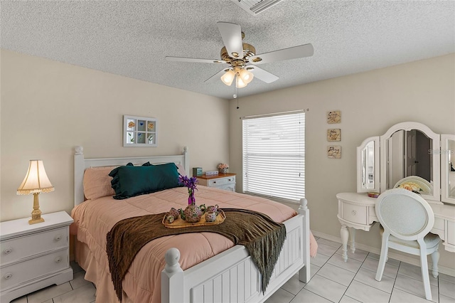 tiled bedroom featuring a textured ceiling and ceiling fan