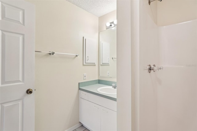 bathroom with tile patterned floors, vanity, and a textured ceiling