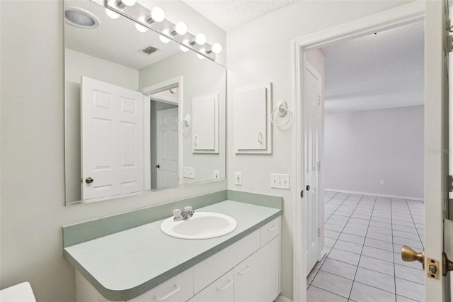 bathroom with vanity, tile patterned floors, and a textured ceiling