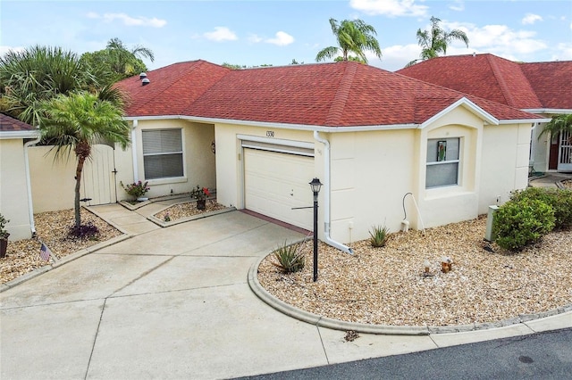 view of front of property featuring driveway, roof with shingles, an attached garage, and stucco siding