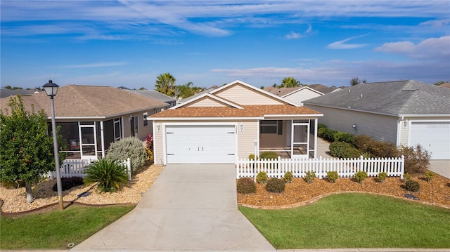 single story home with a sunroom, a garage, and a front yard