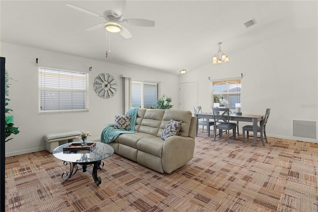 living room featuring vaulted ceiling and ceiling fan with notable chandelier