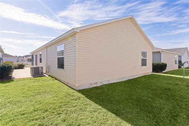 view of side of property with a yard and cooling unit