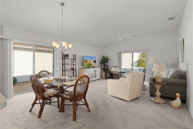 carpeted dining room featuring vaulted ceiling and ceiling fan with notable chandelier